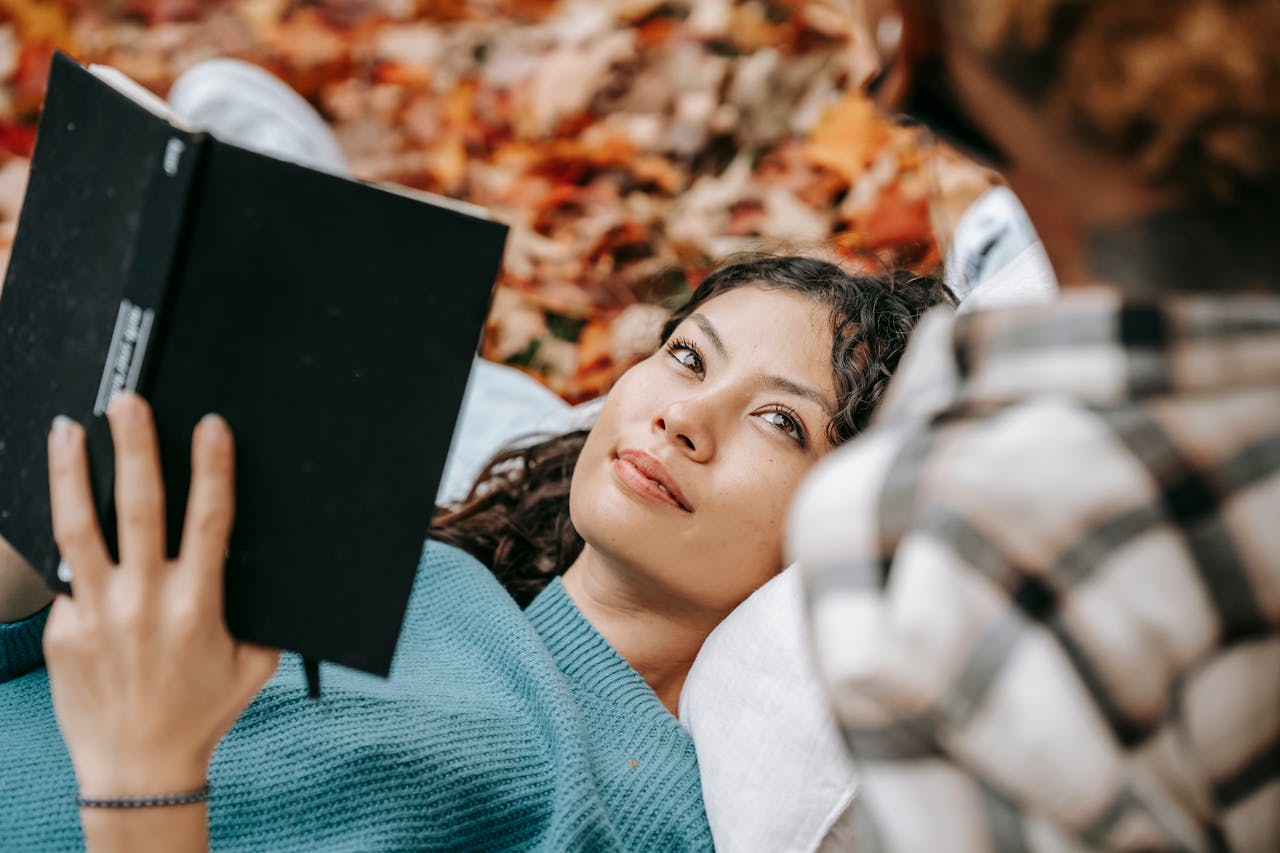 Smiling Hispanic woman with book near crop person